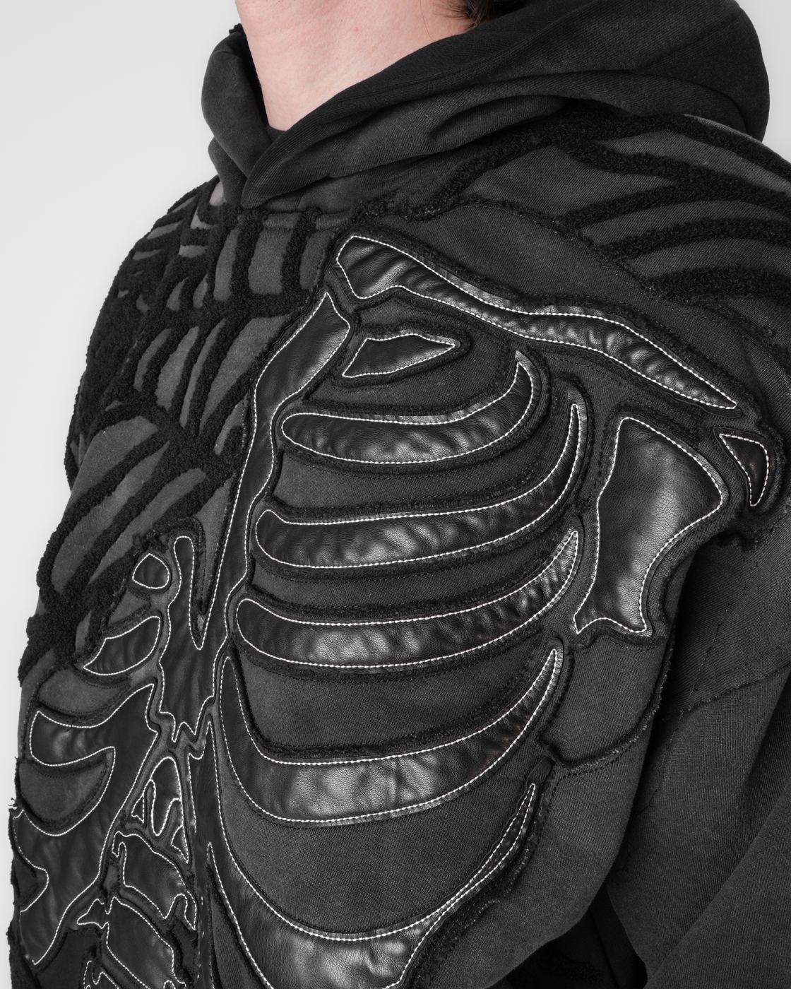 Black skeleton appliqué stitched across a black hoodie