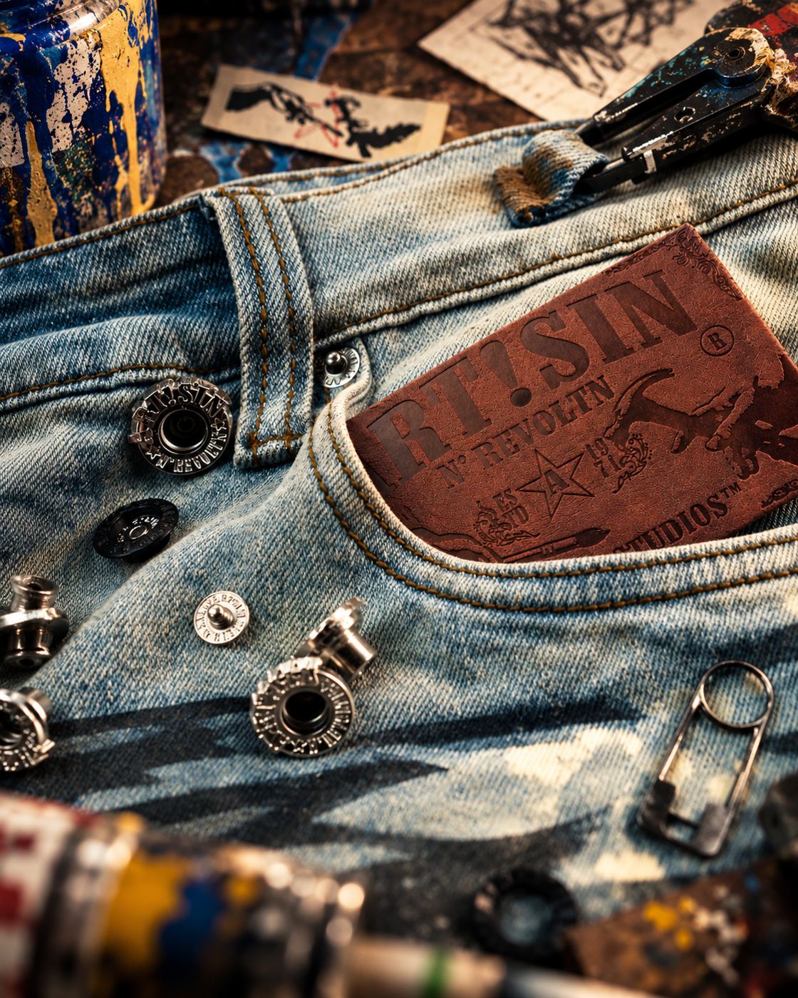 Leather ART!SIN patch and polished metal hardware on washed denim
